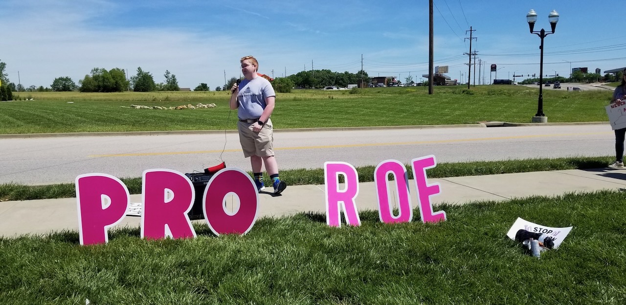 Clayton speaking at an outdoor reproductive rights rally